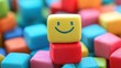 © sambath - A colorful, wooden block with a smiling face on it, surrounded by a pile of other colorful blocks.