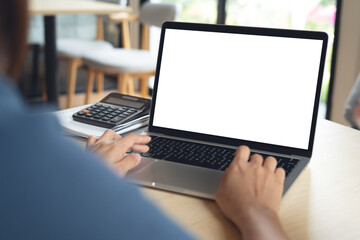 Wall Mural - mockup, woman working on laptop computer with blank white desktop screen on table at home office, mo