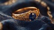 © Aiman Nabeel - Close up of an intricately designed gold ring with delicate engravings set with a sparkling blue sapphire centerpiece displayed against a soft velvet background for elegance