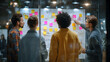 © Abdullah - Team reviewing a whiteboard covered in sticky notes during a late night brainstorming session at the office