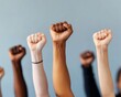 © Preeyanuch - Raised fists of diverse skin tones symbolizing unity, strength, and solidarity against a neutral background.