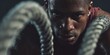© Inna - Man Exercising with Battle Ropes During Workout Session