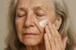 © Oscar - Portrait of an old woman applying face cream