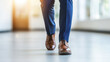 © nattapon98 - Person walking confidently in brown leather shoes and blue formal pants on smooth floor with bright natural light