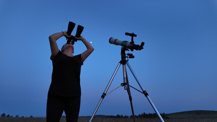 Wall Mural - amateur astronomer using telescope and binoculars for watching stars, moon, planets and other celest
