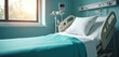 © Pete - Hospital bed with white pillow, teal blanket in clean, modern medical room. Features adjustable sides, monitor nearby. Natural light from window. Focus on patient care environment, healthcare