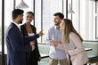 © fizkes - Warm relationships at workplace. Friendly international team 4 diverse employees colleagues gather together at break time chatting laughing having fun in coworking office enjoy informal communication