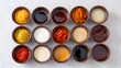 © Kunal - Assortment of cooking ingredients and spices in small bowls arranged on a white surface top view