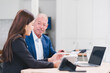 © PRIME STOCK LAB - Young Asian businesswoman and senior Caucasian businessman working together in modern office, discussing documents and using laptop, teamwork and collaboration concept