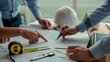 © REZAUL - Architects collaborating on blueprints with tools and technology collaboration planning