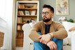 © Dorde - Thoughtful Young Caucasian Man in Glasses Sitting on the Floor of a Bright, Cozy Living Room