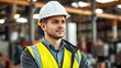 © Leo - Industrial engineer in safety gear, portrait against a factory setting with natural side lighting.