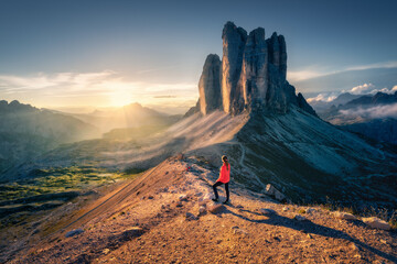 Wall Mural - female hiker enjoying the breathtaking sunrise over the tre cime di lavaredo, three striking peaks r