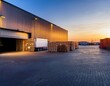© Nicholas - warehouse entrance with truck and pallets illuminated by soft light during early morning hours
