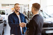 © Anastasiya - Happy client shaking hands with car dealer in showroom after successful deal. Bright expressions of trust and satisfaction in a professional car purchase setting, closeup shot