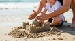 © Viktor - Father and son building sandcastle on sunny beach