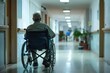 © juliars - Lonely senior man sitting on wheelchair moving in hospital corridor