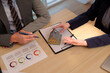 © Pichsakul - Adult professionals hands discuss real estate investment property transaction paperwork reviewing charts office desk during important business meeting financial planning