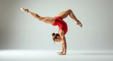 A female gymnast in a handstand, legs extended