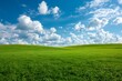© ASAD - Vast rolling green hills under a bright blue sky with fluffy white cumulus clouds on a sunny day