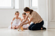 © Cavan Images - Teacher helping student with shoes in a dance class for children
