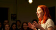 © AIHUN - Young woman speaking passionately to engaged audience in theater