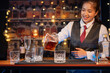 © maeching - Professional female bartender preparing alcoholic drinks in a bar