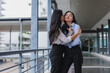 © Phimwilai - Asian businesswomen kissing and embracing on a balcony