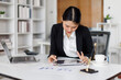 © David - Smiling Asian Woman Working Remotely on Laptop in Modern Workspace