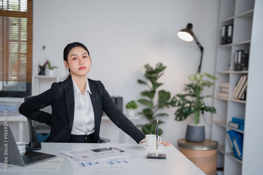 Young professional woman sitting at her desk in a modern office ...