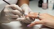 © Meow Creations - Professional manicurist applying intricate floral nail art design on woman nails