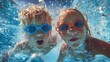 © valeo5 - Two children wearing goggles making funny faces for an underwater selfie in a swimming pool. Perfect for themes of summer fun, childhood, and water activities