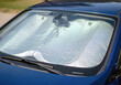 © abu - Close-up of blue car with reflective silver sunshade on windshield