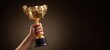© Kazakov - The golden trophy raised in triumph symbolizes success and achievement.