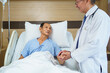 © DG PhotoStock - Doctor and nurse visit elderly male patient in recovery ward in hospital.