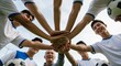 © Arif - Soccer team huddle with coach, hands stacked, smiling faces, low angle view