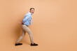 © deagreez - Elegant mature businessman posing against beige background wearing casual formalwear and showcasing a sophisticated confident demeanor