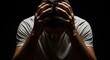 © Николай Срибяник - Stressed man holding head in hands against dark background, expressing mental fatigue, depression or overwhelming emotions in dramatic low-key lighting