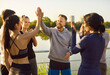 © Studio Romantic - Victory gesture high five of two runners in honor of marathon achievement. Happy fit team of friends celebrate together end of sport challenge and teamwork in summer park. Healthy community concept