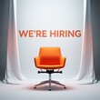 © Risat Designer - An empty bright orange modern office chair sits center stage under a spotlight with the words we re hiring displayed prominently above it