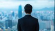 © Anousone - Businessman overlooking a vast city from a high-rise office, leadership, vision