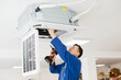 © dsheremeta - Hvac technician installing air conditioner unit using electric drill