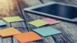 © UdenRafting - Colorful sticky notes and a tablet on a wooden desk.  A workspace with notes for organization and planning