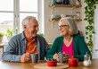© fian - An elderly couple is happily sharing a conversation and likely coffee or tea at a table in their home during the daytime, enjoying a moment of companionship.