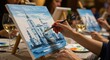 © facegolf - Cityscape Painting Class - A woman paints a cityscape at a paint and sip event. Wine glasses and other canvases are visible