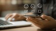 © Jay - Hand holding smartphone with customer feedback icons in front of laptop for service rating