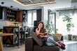 © Migma_Agency - Young woman reading a book on the sofa in a modern apartment