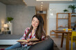 © Migma_Agency - Woman reading a book at home on the sofa