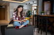 © Migma_Agency - Young woman reading a book at home on the sofa