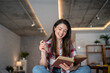 © Migma_Agency - Happy woman reading a book at home and smiling